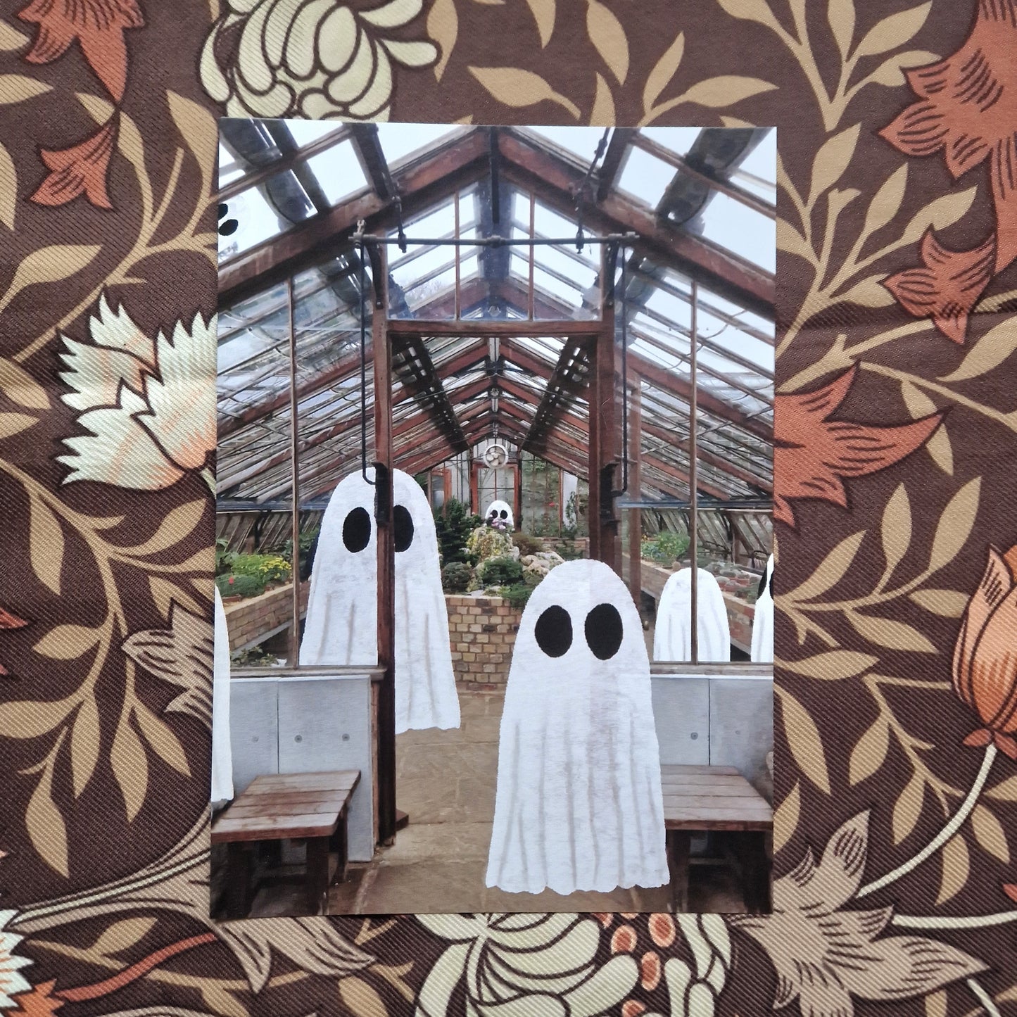 A photo of the inside of a greenhouse with a group of ghost inside sits on a brown floral background
