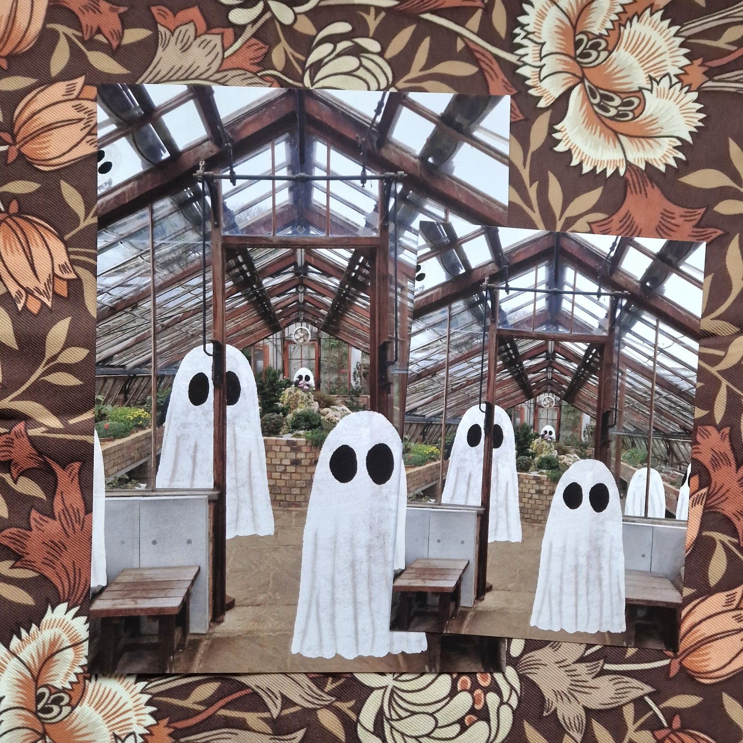 A photo demonstrating the two sizes of print available. The print features a group of ghost drawn onto an image of the inside of a greenhouse.