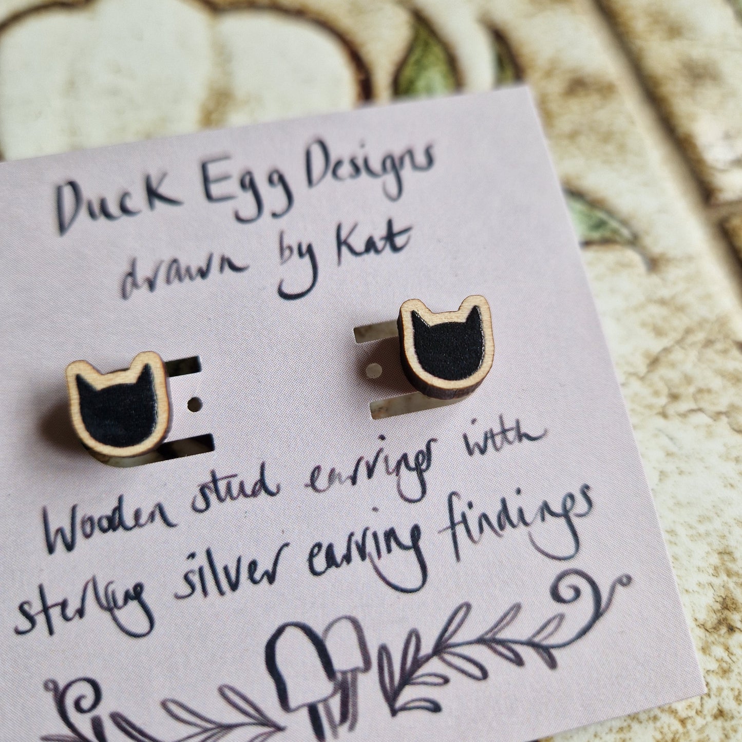 Black Cat Stud Earrings by Duck Egg Designs—wooden studs with sterling silver findings, presented on a card with handwritten details and decorative artwork.