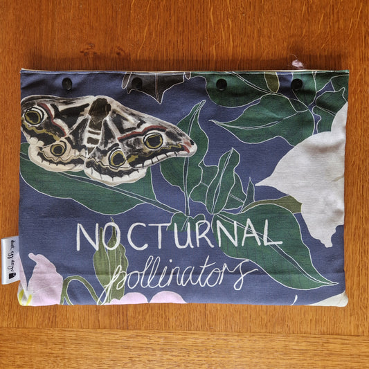 The Nocturnal Pollinators Small Laptop/Tablet Sleeve by Duck Egg Designs is handmade from recycled fabric and features a moth and green leaves illustration on a dark background with NOCTURNAL pollinators printed in white on the front.