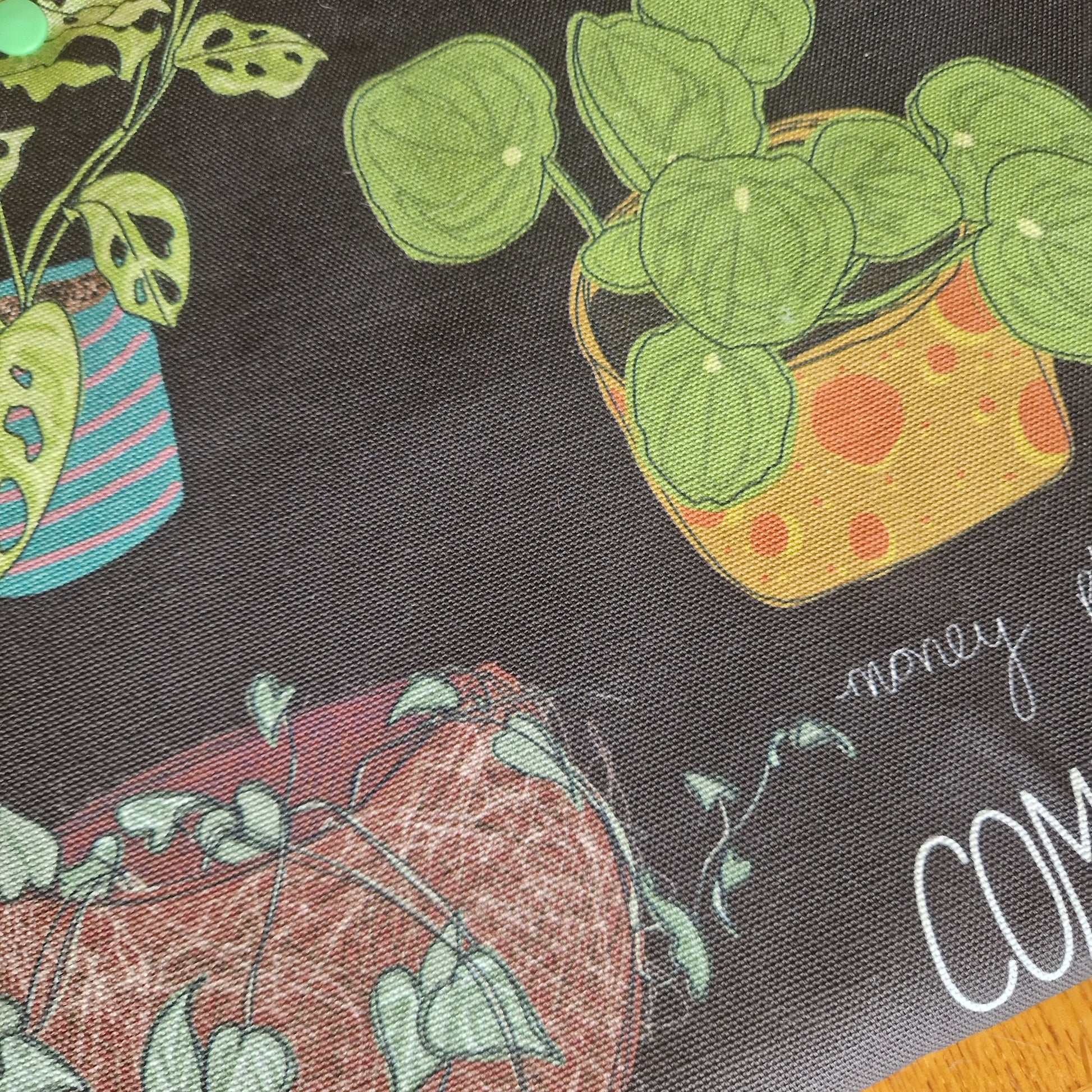 Duck Egg Designs Common Houseplants Small Laptop/Tablet Sleeve features three potted plants—one in a striped blue pot, one in a yellow pot with orange dots, and one in a reddish pot with trailing vines—on dark recycled fabric.