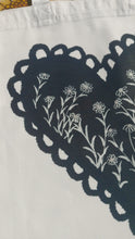 Load image into Gallery viewer, A closer view of the design on the bag showing a section of the black heart with the daisies growing through it.
