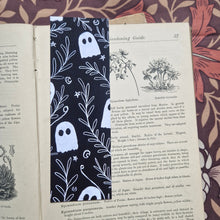 Load image into Gallery viewer, An open vintage gardening book sits on a brown floral patterned background. The book has a black bookmark featuring a white line pattern of ghosts among a leafy vine with stars and crescent moons. 
