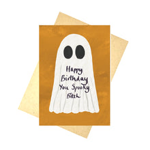 Load image into Gallery viewer, An orange card with a ghost on in sits in front of a recycled brown paper envelope on a white background. The ghost has the words &#39;Happy Birthday You Spooky Bitch&#39; in purple handwriting below its black eyes.
