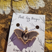 Load image into Gallery viewer, A close up of a wooden printed bat pendant hanging from a sterling silver chain on a white backing card.
