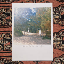 Load image into Gallery viewer, The A5 version of the ghost print sits on a red textured patterned background.  The print features two ghost floating in the shade of pine trees above a sandy beach.
