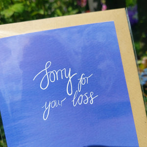 Close up view of the card showing the different blues within it as well as a closer look at the white calligraphy which says 'Sorry for your loss'