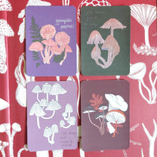 Load image into Gallery viewer, Four mini postcards with rounded edges in a square formation on top of a red background with white fungi illustrations. From L to R, top to bottom is a purple postcard featuring fungi and ferns, a dark green postcard featuring fungi, a dusty pink fungi postcard and a dark red fungi and oak leaf postcard.
