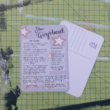 Load image into Gallery viewer, Front and back of a postcard are visible on a green cutting mat. The front is pale purple with a handwritten star gingerbread recipe. The back is white with lines for the address and a square for the stamp as well as the duck egg designs logo.
