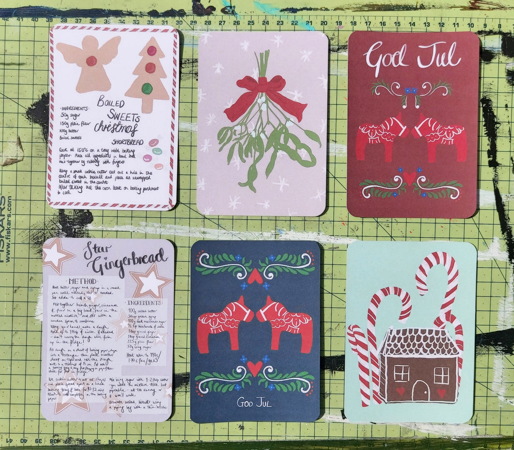 All six postcard designs shown in two rows of three on a green cutting mat.