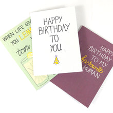 Load image into Gallery viewer, Pile of different card designs with the white birthday card at the top. 
