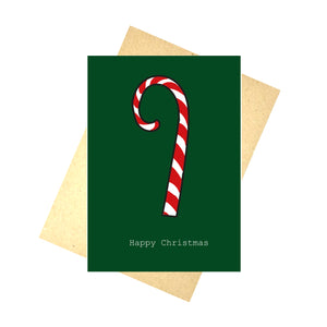 A green card featuring a white and red candy cane with white writing below that says 'Happy Christmas'. Behind the card is a brown envelope, behind which is a white background.
