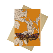Load image into Gallery viewer, Vibrant orange card with pale orange brambles and a death head moth illustration central at the bottom. Behind the card is a brown envelope below which is a white background.
