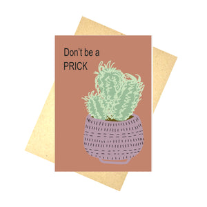 A warm orange card featuring a fluffy green cactus in a purple pot, to the top left of the card are the words Don't be a PRICK in black writing. Behind the card is a brown envelope, behind which is a white background.