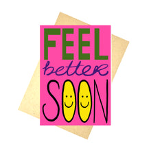 Load image into Gallery viewer, Bright pink card featuring the words &#39;FEEL better SOON&#39; with feel in block green letters, better in purple cursive writing and soon in black capital letters with yellow smiley faces on the inside of the os. Behind the card is a recycled brown envelope behind which is a white background.

