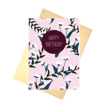 Load image into Gallery viewer, Pale pink card featuring an all over blue and white floral pattern with green vines. Towards the top centre of the card is a plum coloured circle with the words &#39;HAPPY BIRTHDAY&#39; in pale pink. Underneath the card you can see a recycled brown paper envelope which is on top of a white background.

