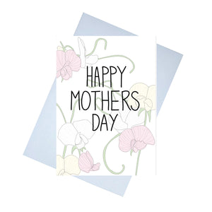 A white card featuring sweet peas in muted green, pink and cream. In front of the sweet peas are the words HAPPY MOTHERS DAY in black handwriting across the middle. Behind the card is a lilac envelope, behind which is a white background.